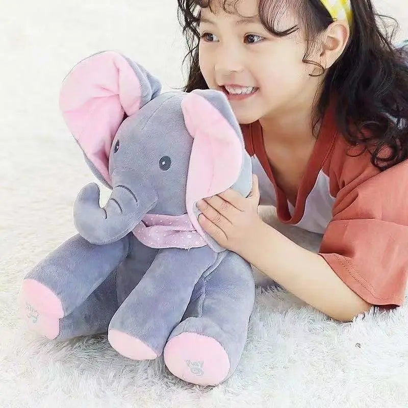 Child holding a plush elephant toy on a soft surface